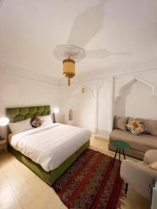 马拉喀什RIAD KECHMARA的一间卧室配有一张大床和一张沙发