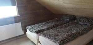 阿克雷里Akureyri Loghouse的一间卧室设有两张床和木墙