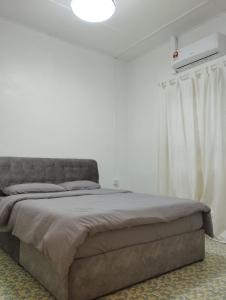 峇株巴辖Batu Pahat Taman Banang Homestay的卧室内的一张床位,卧室设有白色的墙壁