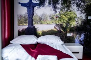 卢布林地区亚努夫Janowski Zakątek的一张带枕头的床和十字架雕像
