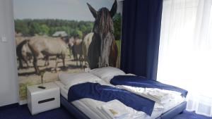 卢布林地区亚努夫Janowski Zakątek的卧室配有一张挂有壁画的马床。