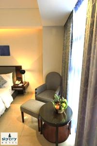 达卡达卡天空之城酒店的客厅配有椅子和桌子