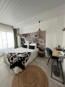 鲁西隆地区卡内Hôtel Les Sables - Urban Style - by Logis Hotels的一间卧室配有两张床、一张桌子和一张书桌