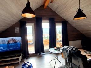 阿克雷里Akureyri Loghouse的一间带电视和大窗户的客厅