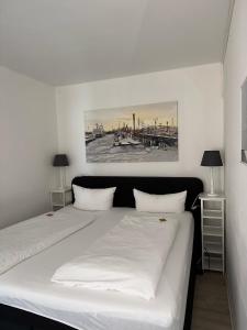 威克奥夫弗尔斯特兰德酒店的一间卧室配有一张带两盏灯的大型白色床。