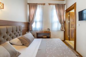 穆达尼亚阿尔米思提斯酒店的一间卧室设有一张大床和一个窗户。