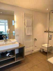 威克奥夫弗尔斯特兰德酒店的一间带水槽、淋浴和卫生间的浴室