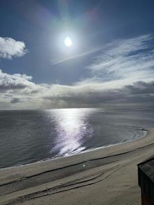 威克奥夫弗尔斯特兰德酒店的阳光反射在水面上的海滩