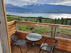 阿克雷里Akureyri Loghouse的湖景阳台配有桌椅
