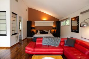 彭伯顿Silkwood Estate的客厅里一张红色的沙发,配有一张床
