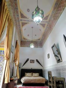Sidi Abd el KaderRiad Freija-TAROUDANT的一间卧室配有一张床和一个吊灯