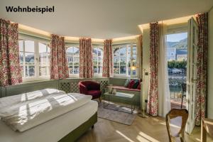 巴德伊舍贡德耐奥克斯酒店的一间卧室配有一张床,另一间设有窗户。