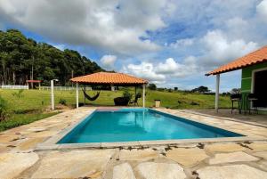 卡兰卡斯Pousada Sal da Terra的一个带遮阳伞的庭院内的游泳池