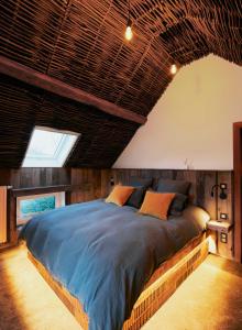 RonquièresCharly 132的一间卧室设有一张带木制天花板的大床