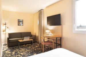 圣西尔-莱科勒ibis Styles Versailles Saint Quentin en Yvelines的酒店客房设有沙发、书桌和笔记本电脑