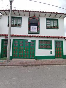 蒙圭ApartaHotel Monguí的街道上设有绿色和红色门的建筑