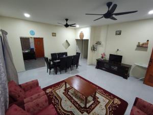 Kampong Bukit ChinaMan Homestay的客厅配有沙发和桌子