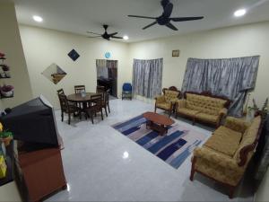 Kampong Bukit ChinaMan Homestay的带沙发的客厅和用餐室