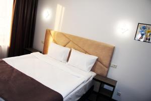 埃里温Nice Hotel Yerevan的酒店客房配有带白色床单和枕头的床。