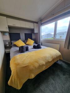 帕兹托Seven Sunsets, Padstow的一间卧室配有一张带黄色枕头的大床