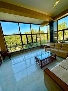 瓦拉纳西Kaashi Flora - Luxury 3BHK的带沙发和玻璃桌的客厅
