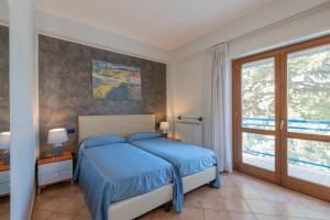 拉奎拉Hotel Azzurro的一间卧室设有蓝色的床和窗户。
