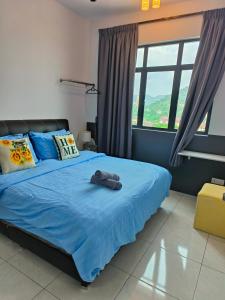 峇六拜The Sun 1 or 3BR Bayan Lepas 4 to 10 pax的一间卧室配有一张带蓝色床单和窗户的床。