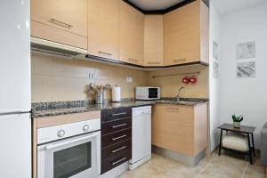 El Lligallo del GànguilEncantador apartamento en El Delta del Ebro-Apartaments Iaio Kiko的厨房配有白色家电和木制橱柜