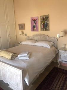 雅典Sea View House Voula的卧室内的一张白色床,墙上挂着两张照片