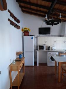 蒙萨拉什Casa do Celeiro - Monsaraz的厨房配有白色冰箱和桌子