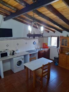 蒙萨拉什Casa do Celeiro - Monsaraz的厨房配有桌子和洗衣机。