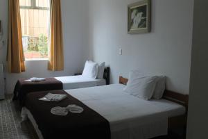波梅罗迪Pousada Max Pomerode的酒店客房设有两张床和窗户。