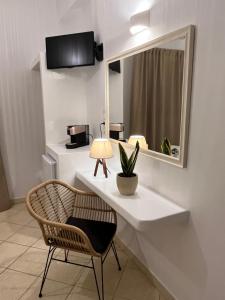 安迪帕罗斯岛Hotel Chrisoula的一张带椅子和镜子的白色书桌