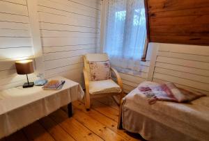 拉普斯尼恩Miodowa Chata的客房设有两张床、椅子和桌子。