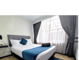 波哥大Hotel CGH Bogota Airport的一间卧室设有一张大床和大窗户