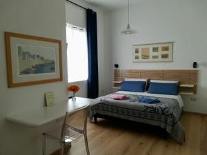 斯廷蒂诺Domo Sul Porto的一间卧室配有一张带蓝色枕头的床和一张桌子