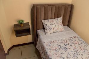 齐克拉约Hermoso Departamento dentro de un Condominio的一张带枕头的小床和一个床头柜