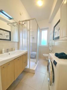 莫内利亚COMFORTABLE SEA HOLIDAYS AND WALKS的一间带水槽和洗衣机的浴室