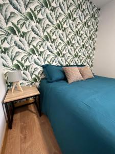 梅克西米约Les gîtes de la bergerie的一间卧室配有一张蓝色的床和壁画