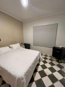 门多萨Gomez Point Mendoza的卧室配有白色的床和 ⁇ 格地板