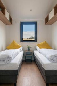恩基尔希Velo & Wohnen -NEU- Elektroräder inklusive-Sauna-Moselblick的带窗户的客房内设有两张单人床。