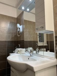 多马索Alexandra's Sunset Apartment的浴室设有白色水槽和镜子