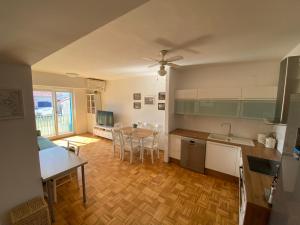 皮兰Lucy Apartment Piran-Punta的厨房以及带桌椅的起居室。