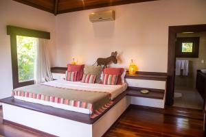 皮帕多莫斯别墅酒店的一间卧室配有一张带红色枕头的大床