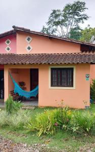 佩尼多Sitio148 Hospedaria的前面有蓝色吊床的房子