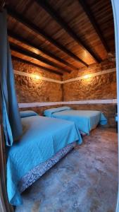 Santa ElenaHotel Colibrí Petén的客房位于带木制天花板的建筑内,设有两张床。