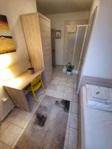 特伦钦温泉镇Cityap Apartments的一间带书桌的浴室和一张位于客房内的床。
