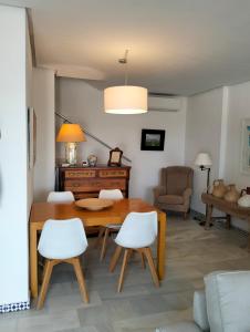 奇克拉纳－德拉弗龙特拉Casa Sargo的客厅配有木桌和白色椅子