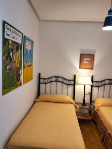 奇克拉纳－德拉弗龙特拉Casa Sargo的一间卧室配有两张床和一盏灯