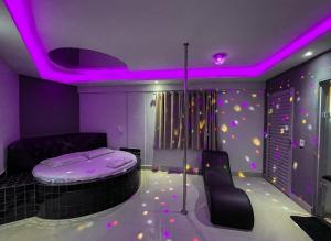 塔瓜汀加Motel Gold的一间设有一张床和紫色天花板的客房